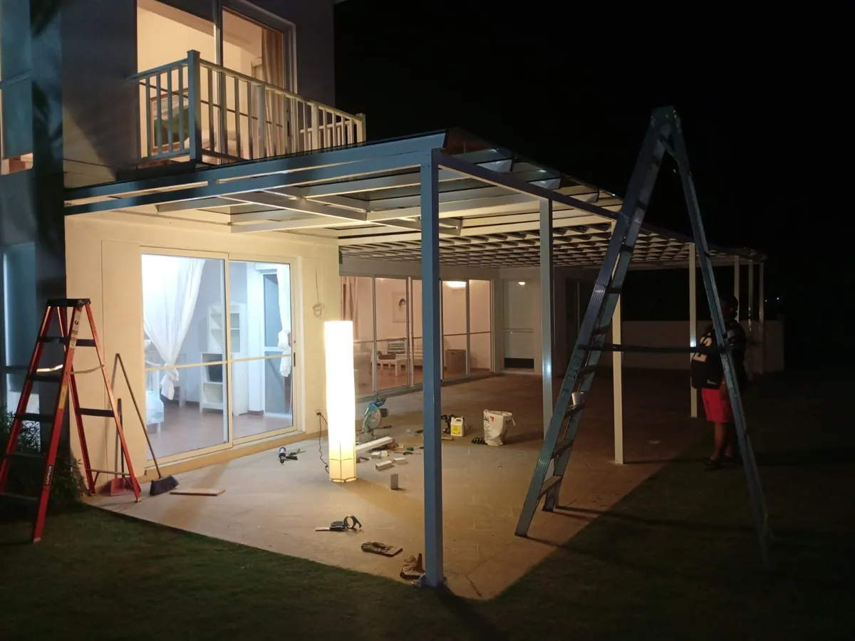 Pérgola iluminada de noche junto a la casa